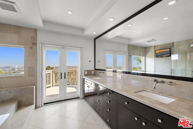 a large kitchen with granite countertop a large counter top a sink and stainless steel appliances