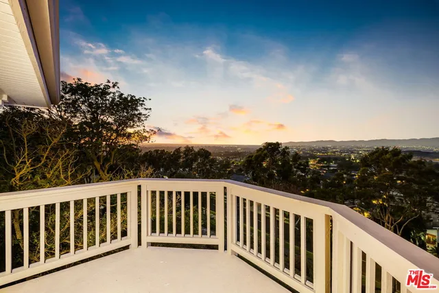 a view of a balcony with wooden fence and floor