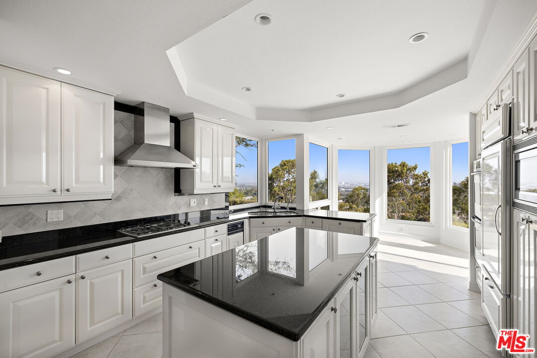 31 St Tropez Newport Beach, CA 92660 - Photo 5 of 22 a kitchen with granite countertop stainless steel appliances a sink and cabinets