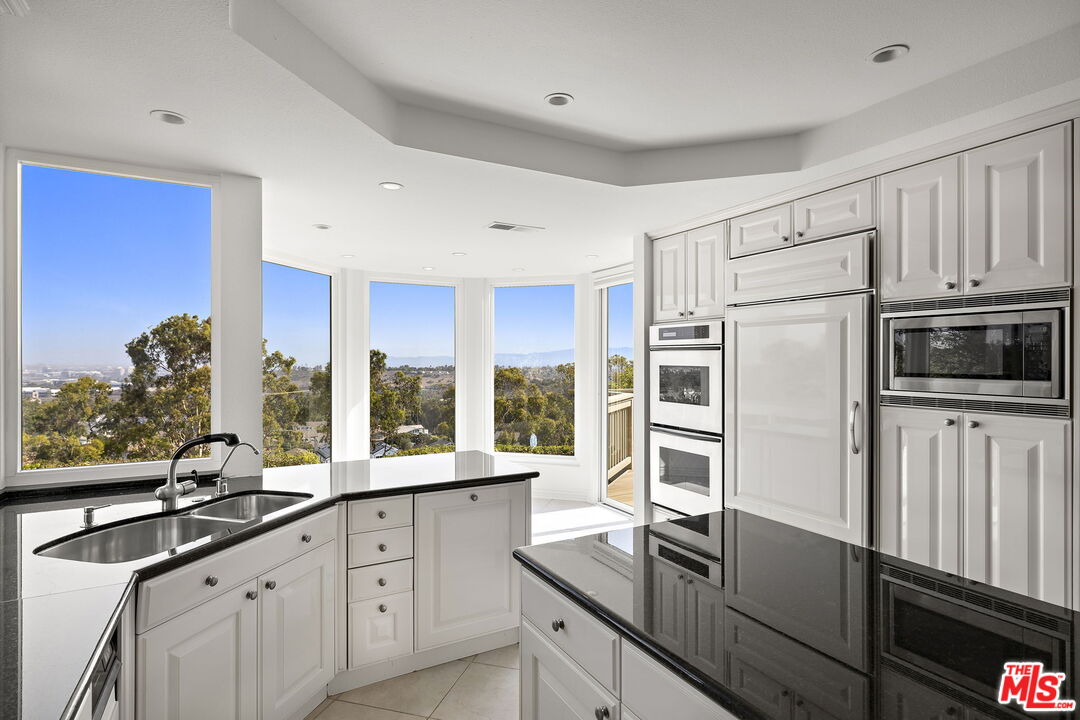 31 St Tropez Newport Beach, CA 92660 - Photo 6 of 22 a kitchen with stainless steel appliances a sink stove and refrigerator