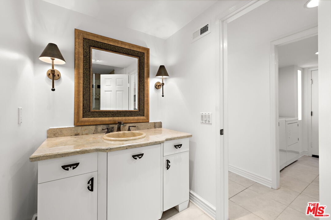 31 St Tropez Newport Beach, CA 92660 - Photo 8 of 22 a bathroom with a granite countertop sink and a mirror
