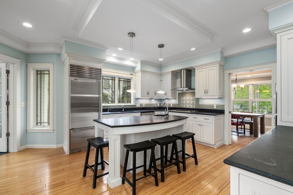 51 Avon Road Wellesley, MA 02482 - Photo 3 of 26 a kitchen with stainless steel appliances granite countertop a kitchen island hardwood floor sink stove dining table and chairs