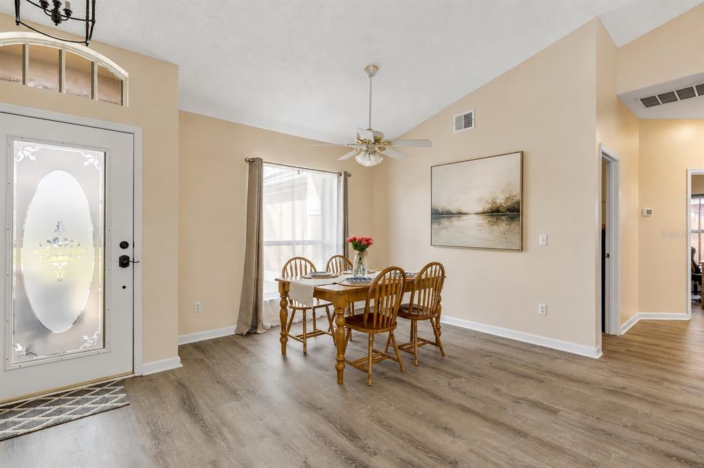 12232 Bronson Way Orlando, FL 32824 - Photo 9 of 32 a dining room with wooden floor a glass table and chairs
