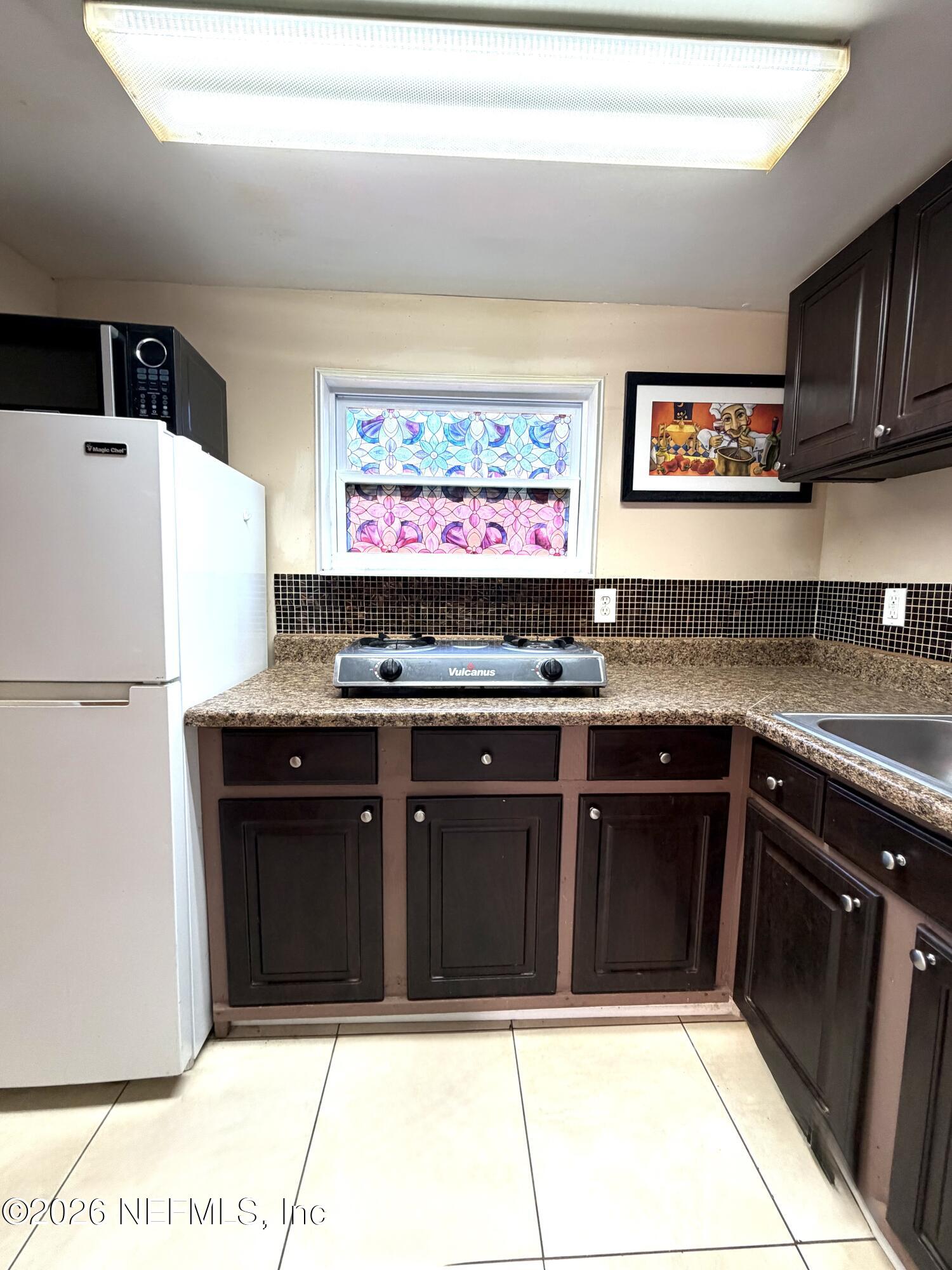 4127 Springwood Road Jacksonville, FL 32207 - Photo 57 of 63 a kitchen with stainless steel appliances granite countertop a refrigerator and a sink