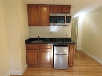868 Beacon Street, Unit A Boston, MA 02215 - Photo 4 of 5 a kitchen with granite countertop wood cabinets and stainless steel appliances