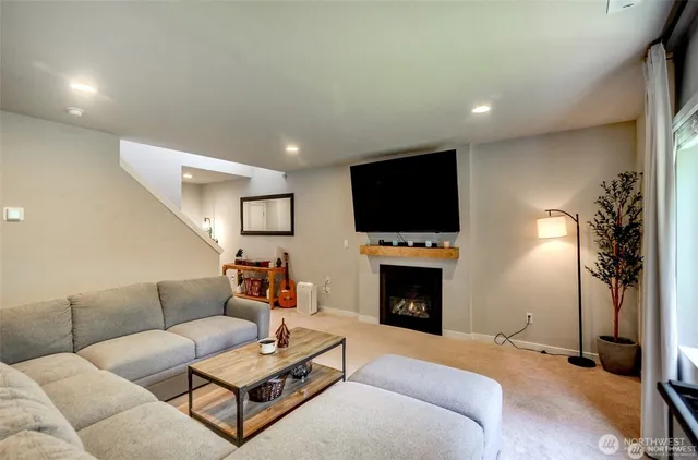 a living room with furniture a fireplace and a flat screen tv