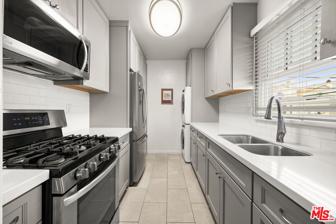 1137 26th Street, Unit D Santa Monica, CA 90403 - Photo 4 of 14 a kitchen with stainless steel appliances granite countertop a sink and a stove