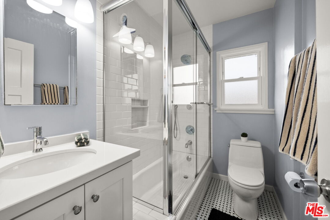 1137 26th Street, Unit D Santa Monica, CA 90403 - Photo 7 of 14 a bathroom with a sink a toilet a mirror and shower