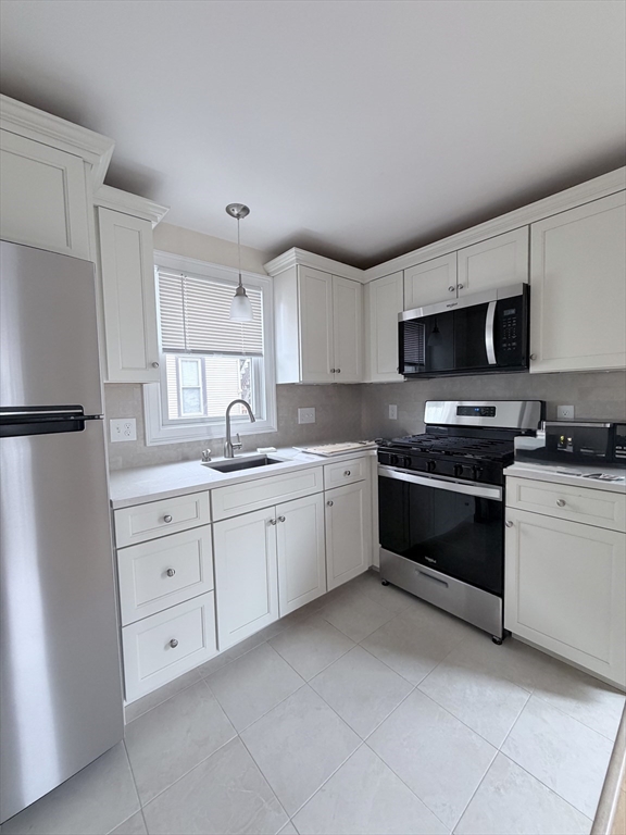 26 Brooks Street, Unit 2 Boston, MA 02128 - Photo 1 of 12 a kitchen with granite countertop white cabinets and stainless steel appliances