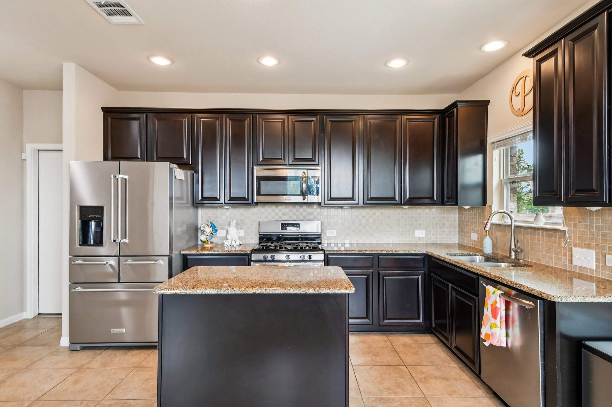 125 Checkerspot Court Georgetown, TX 78626 - Photo 12 of 40 a kitchen with a sink refrigerator and cabinets