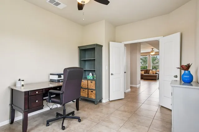 a view of a workspace with furniture and a window