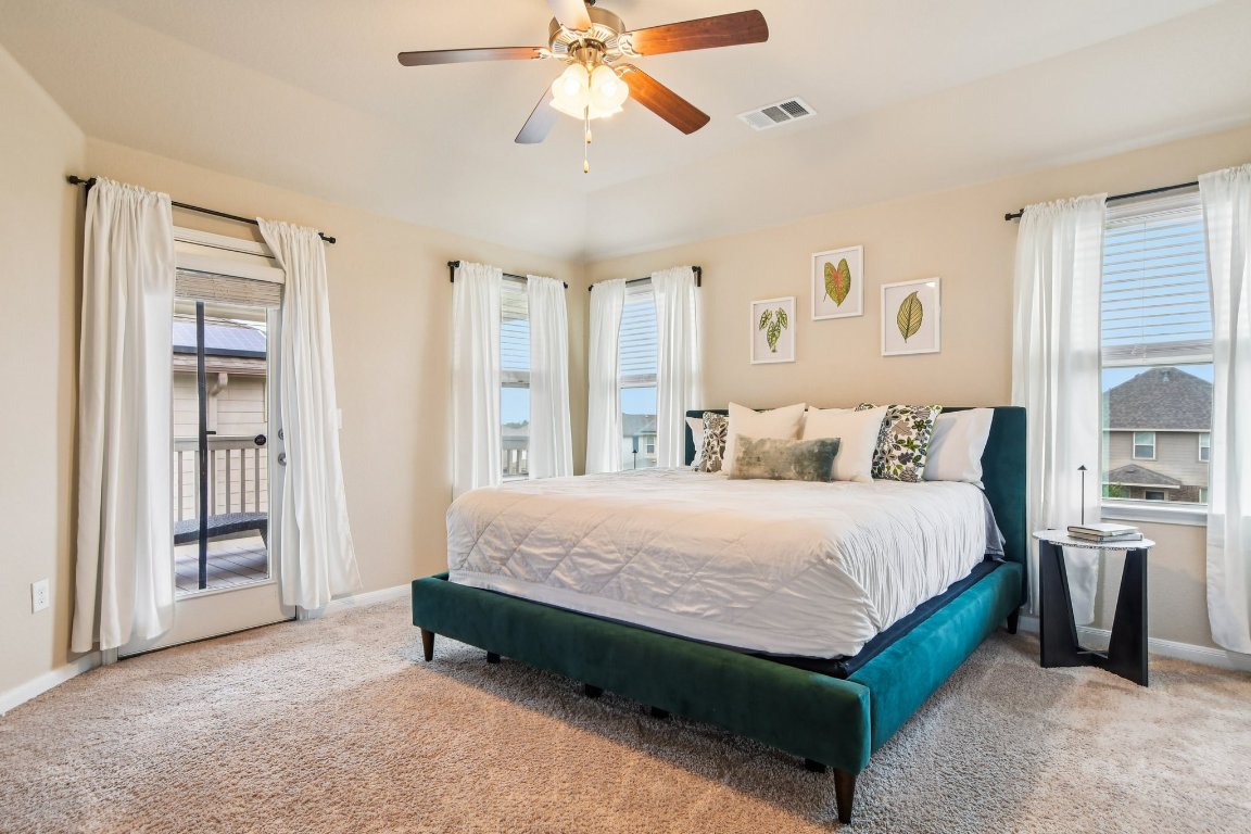 125 Checkerspot Court Georgetown, TX 78626 - Photo 18 of 40 a spacious bedroom with a bed a window and a chandelier