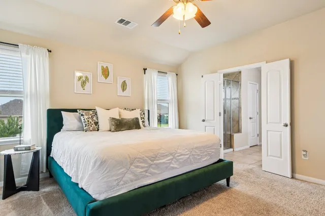 a bedroom with a large bed and a chandelier