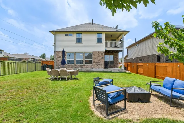 a view of a house with backyard and sitting area