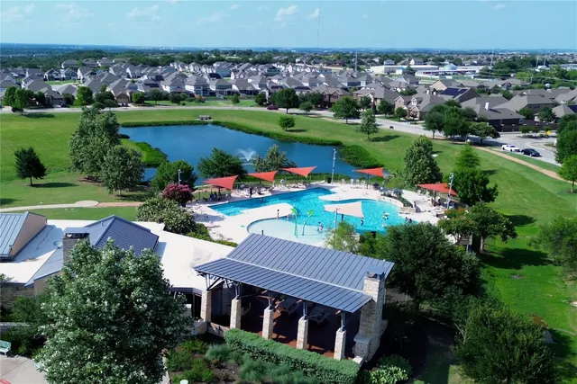 an aerial view of a house with a garden and lake view