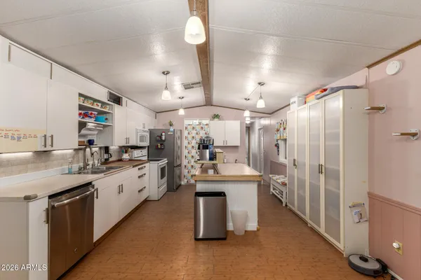 a kitchen with stainless steel appliances lots of counter top space and refrigerator