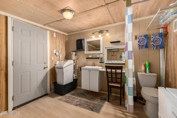 a view of bathroom with a toilet sink a mirror and a shower