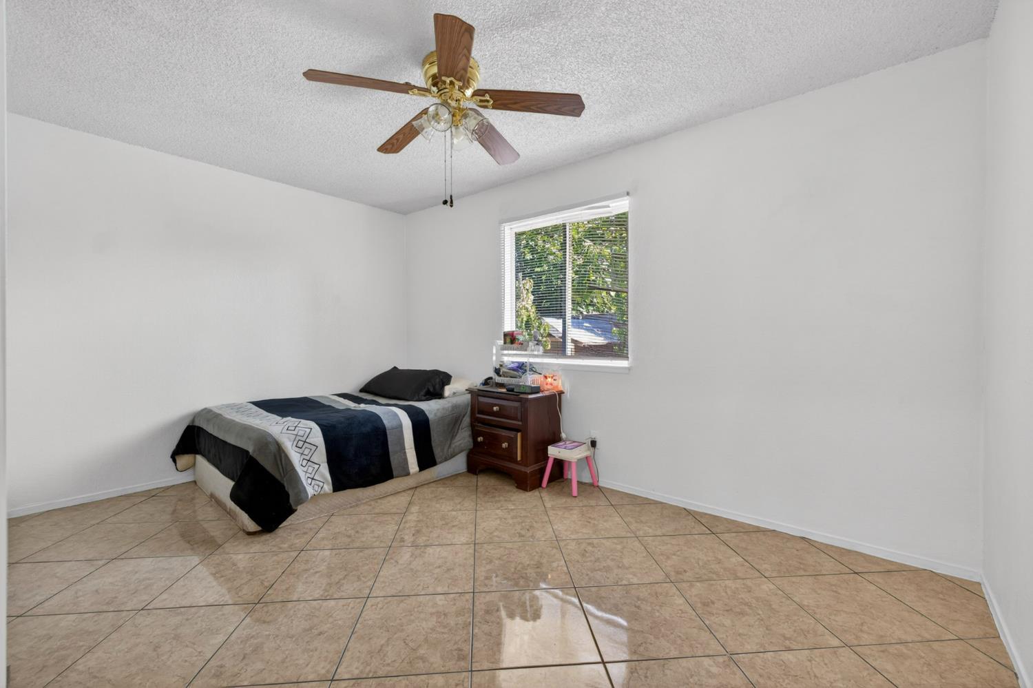 13591 East 5th Street Parlier, CA 93648 - Photo 16 of 31 a bedroom with a bed and a chandelier