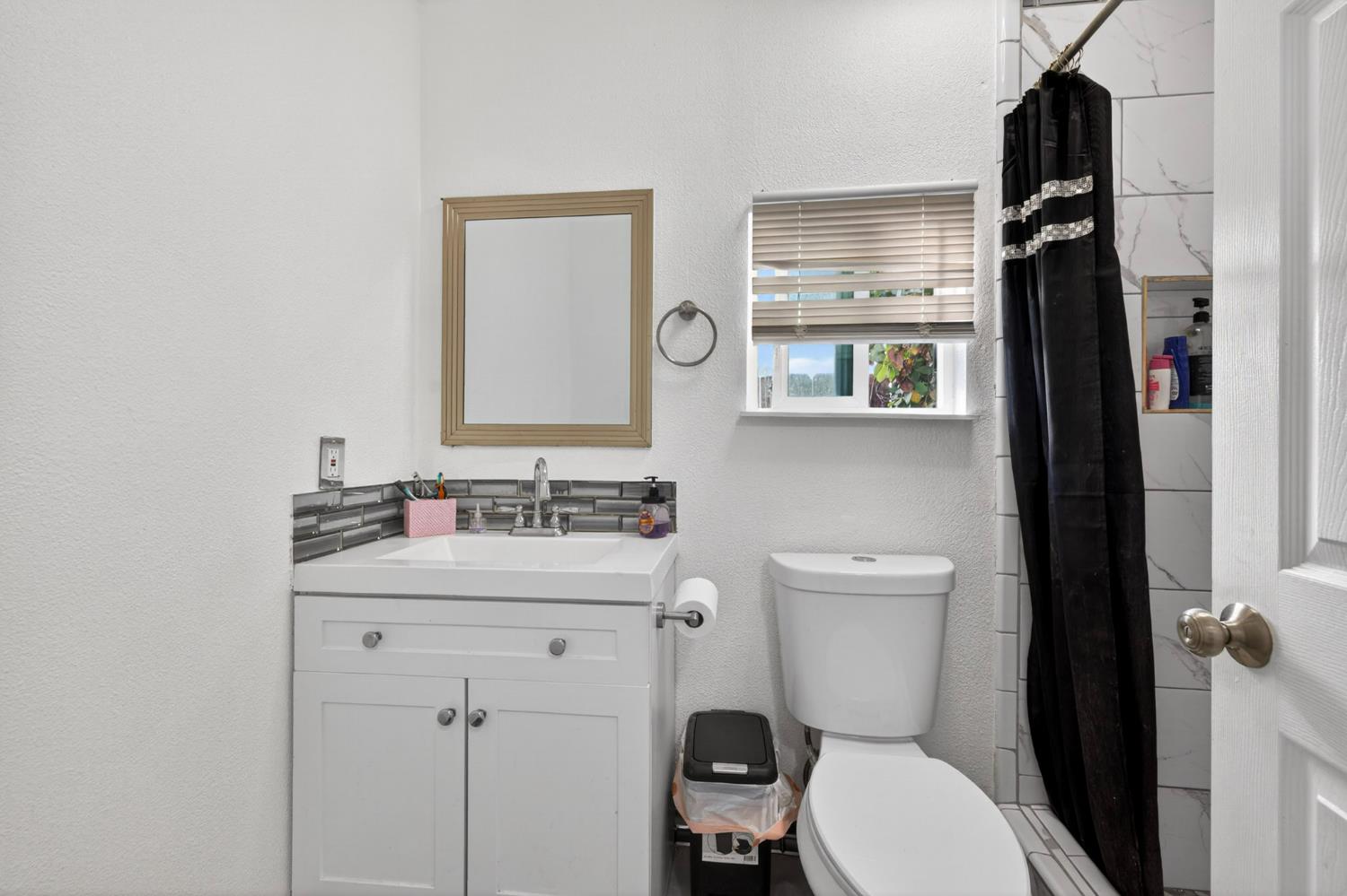 13591 East 5th Street Parlier, CA 93648 - Photo 20 of 31 a bathroom with a toilet a sink and a mirror