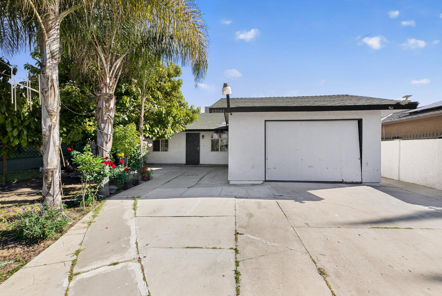 13591 East 5th Street Parlier, CA 93648 - Photo 2 of 31 a front view of a house with a yard and garage