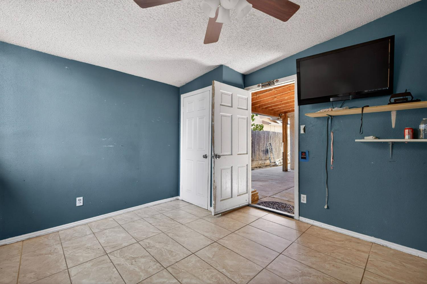 13591 East 5th Street Parlier, CA 93648 - Photo 26 of 31 a view of a livingroom with an empty space and a flat screen tv