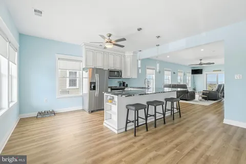 a kitchen with granite countertop a sink stove and refrigerator