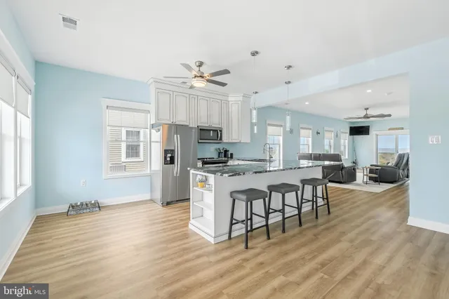 a kitchen with granite countertop a sink stove and refrigerator