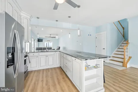 a kitchen with stainless steel appliances granite countertop a stove top oven a sink and a refrigerator