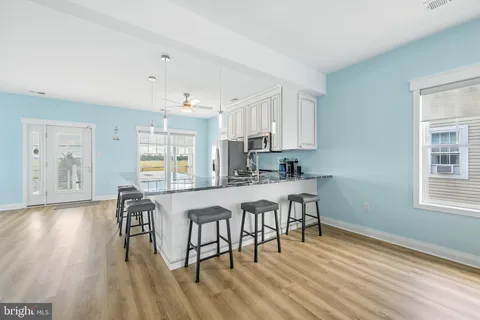 a kitchen with granite countertop white cabinets and chairs