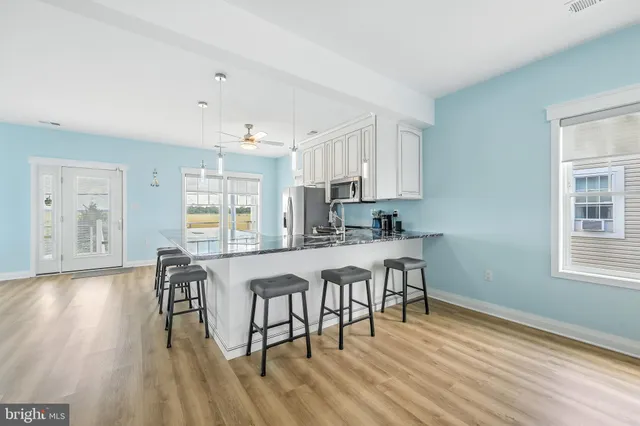 a kitchen with granite countertop white cabinets and chairs