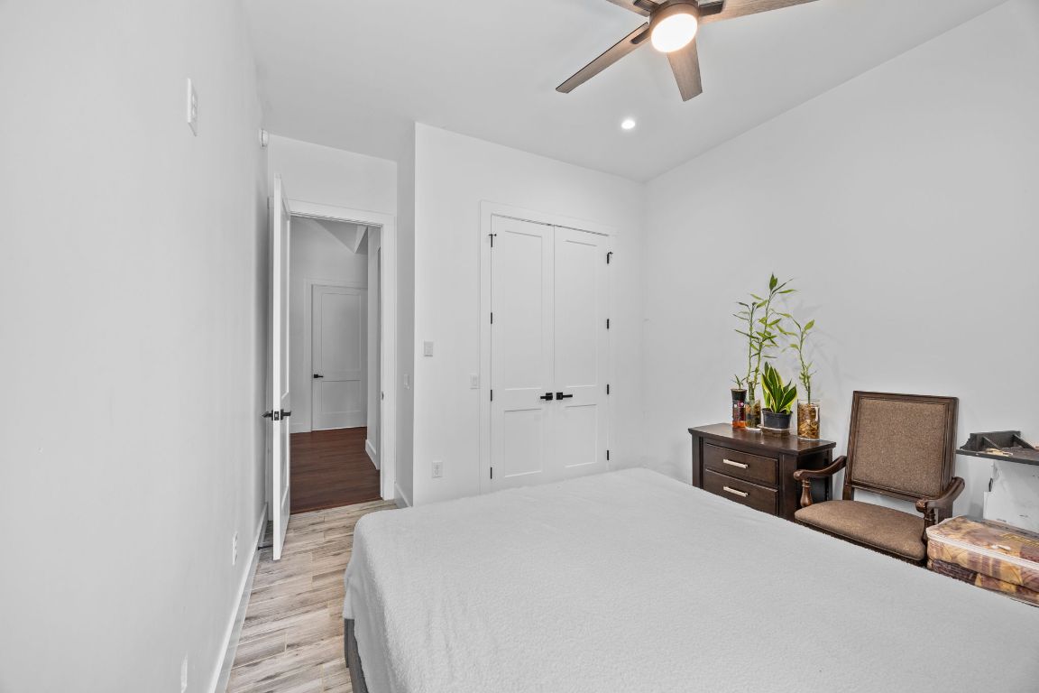 390 Riddle Road Cedar Creek, TX 78612 - Photo 24 of 27 a bedroom with a bed and a chandelier