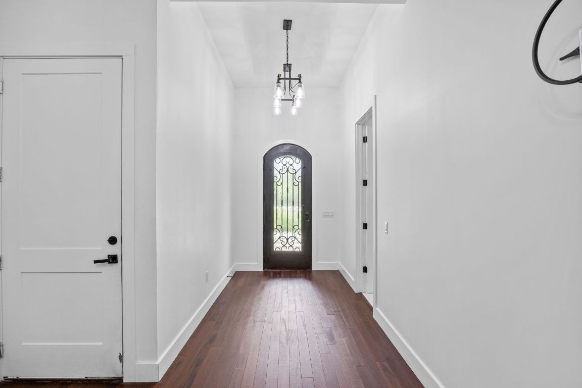 390 Riddle Road Cedar Creek, TX 78612 - Photo 4 of 27 a view of a hallway with wooden floor and windows