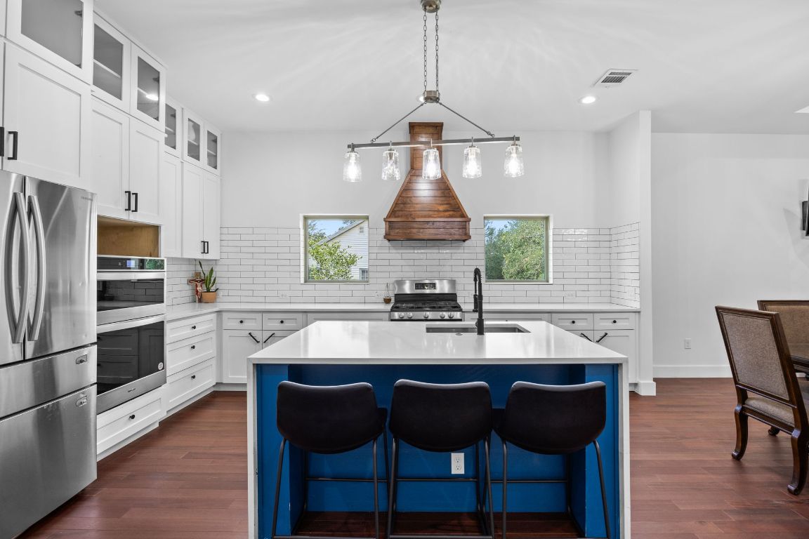 390 Riddle Road Cedar Creek, TX 78612 - Photo 7 of 27 a kitchen with a chandelier dining table and chairs