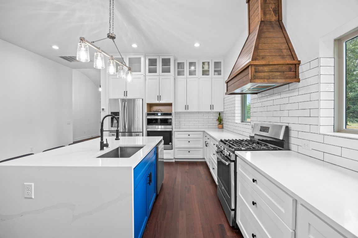 390 Riddle Road Cedar Creek, TX 78612 - Photo 9 of 27 a kitchen with stainless steel appliances granite countertop a sink a stove and a refrigerator