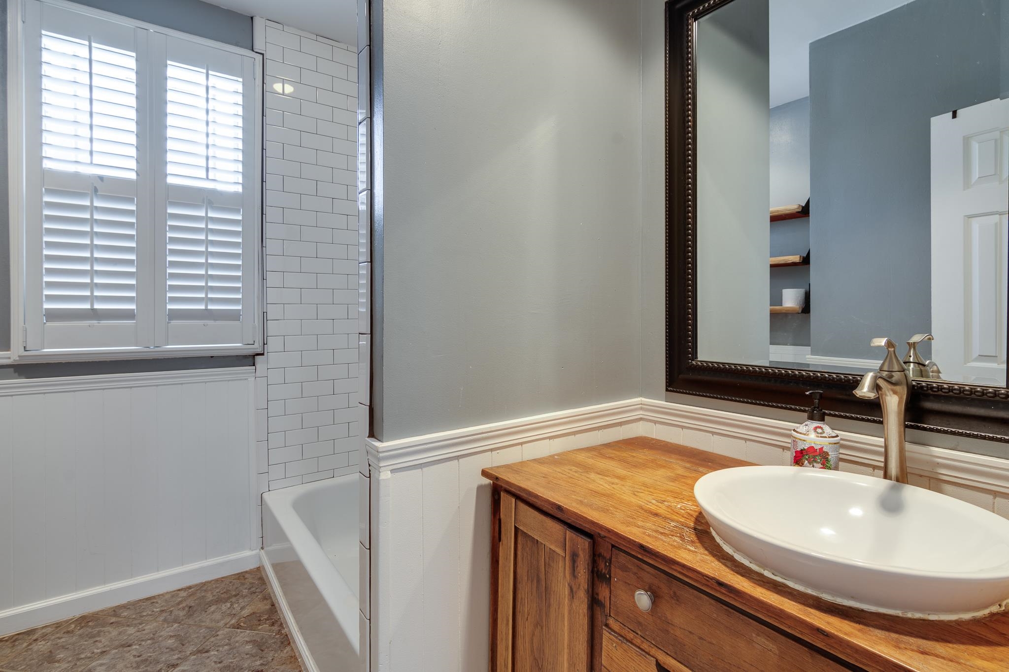 520 Ellsworth Street Memphis, TN 38111 - Photo 26 of 37 Bathroom featuring vanity, wainscoting, and bathtub / shower combination
