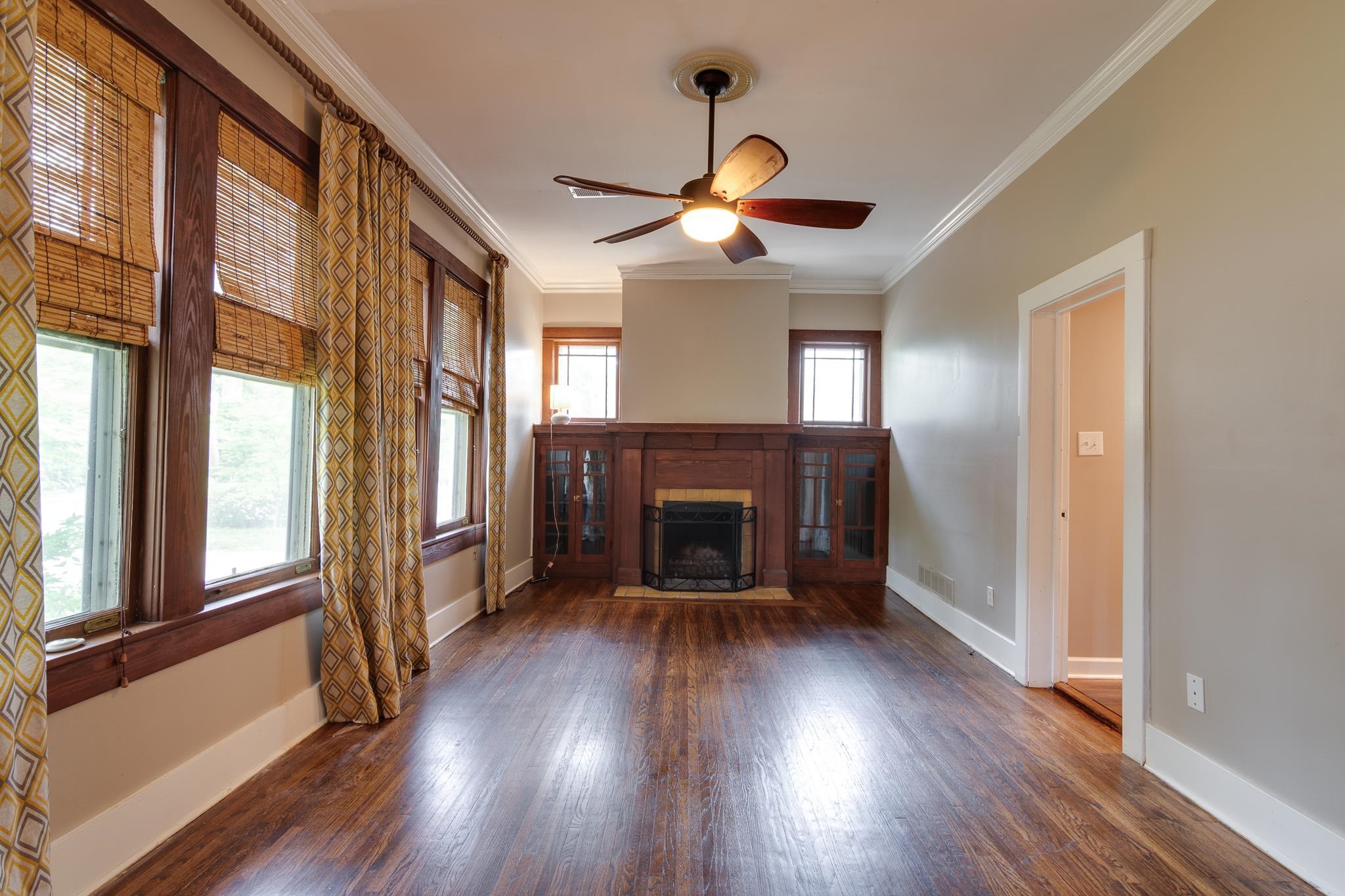 520 Ellsworth Street Memphis, TN 38111 - Photo 7 of 37 Unfurnished living room featuring ornamental molding, wood finished floors, ceiling fan, and a fireplace