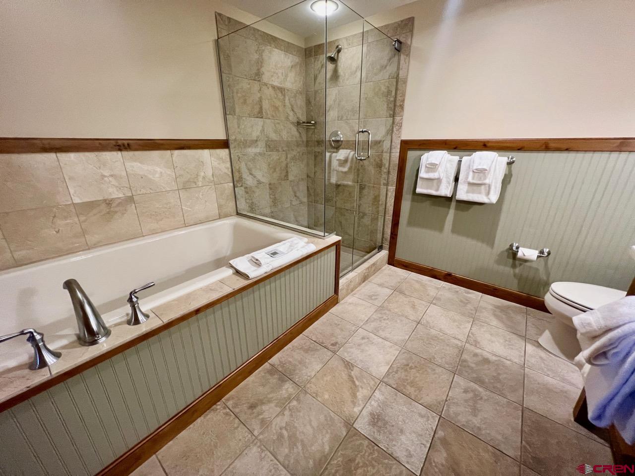 620 Gothic Road, Unit 606 Crested Butte, CO 81225 - Photo 19 of 28 a spacious bathroom with a tub sink and mirror