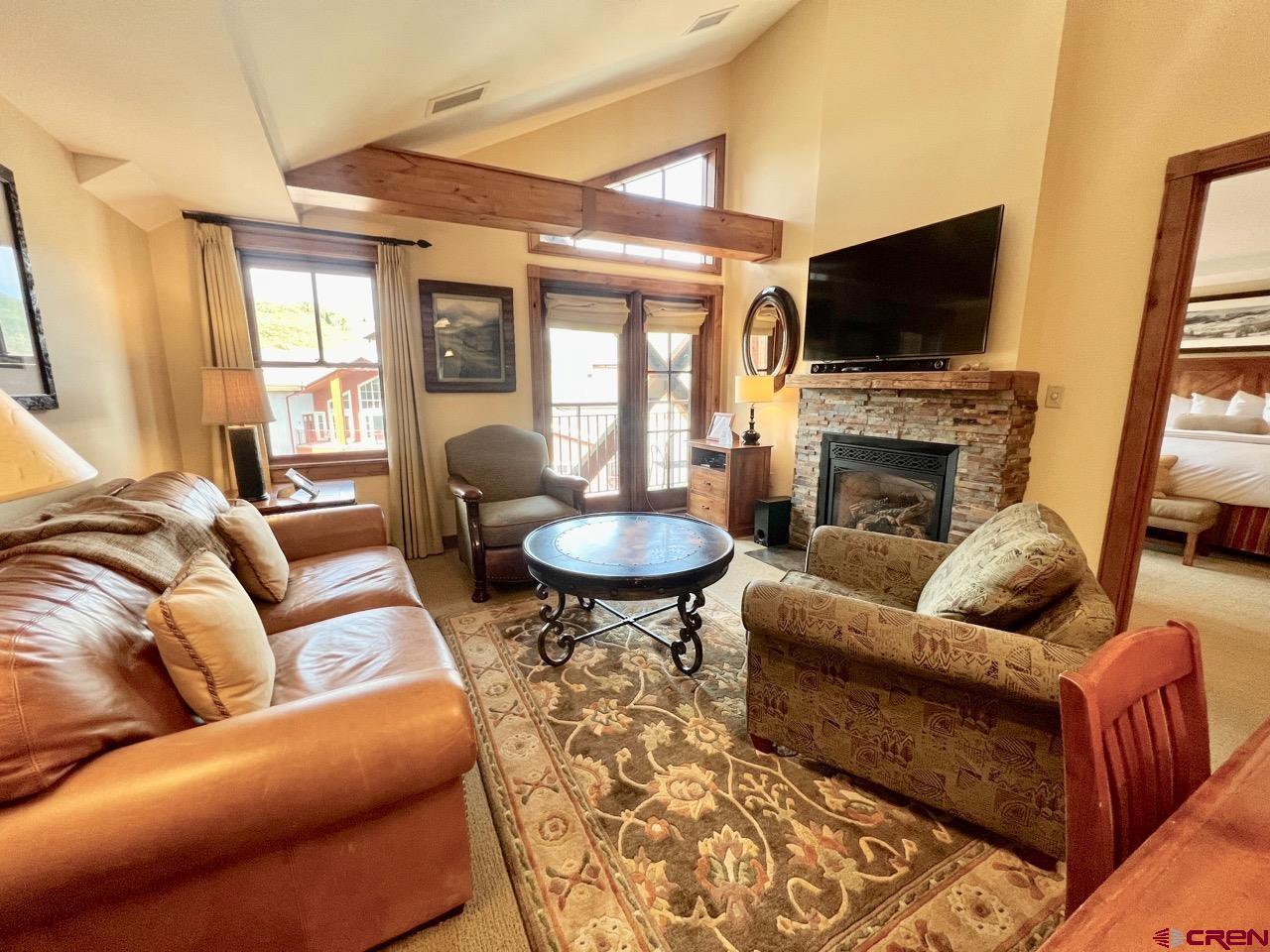 620 Gothic Road, Unit 606 Crested Butte, CO 81225 - Photo 3 of 28 a living room with furniture a fireplace and a flat screen tv