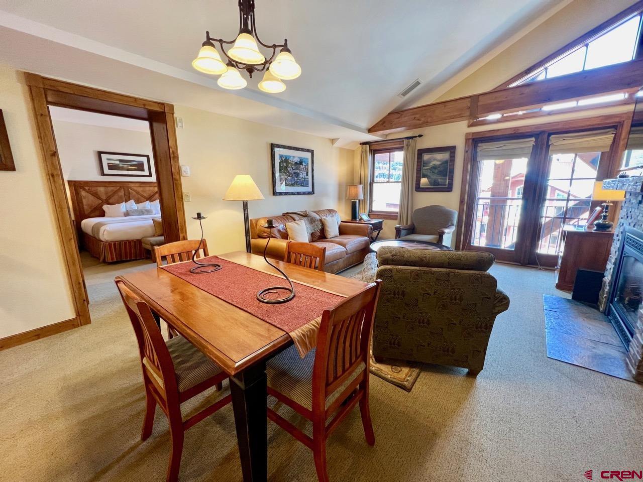 620 Gothic Road, Unit 606 Crested Butte, CO 81225 - Photo 5 of 28 a dining room with wooden floor a chandelier fan a wooden table and chairs