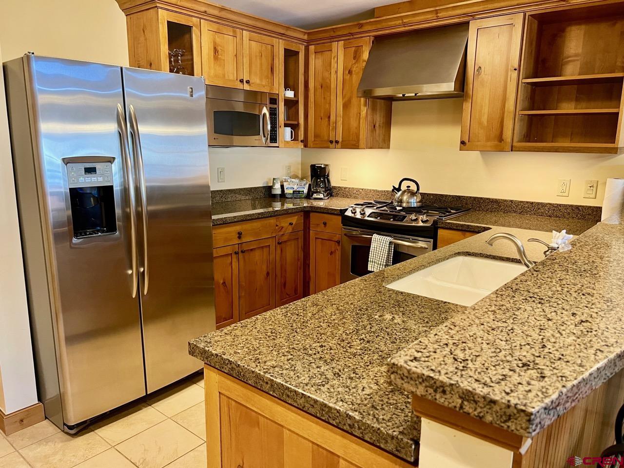 620 Gothic Road, Unit 606 Crested Butte, CO 81225 - Photo 7 of 28 a kitchen with stainless steel appliances granite countertop a sink stove and refrigerator