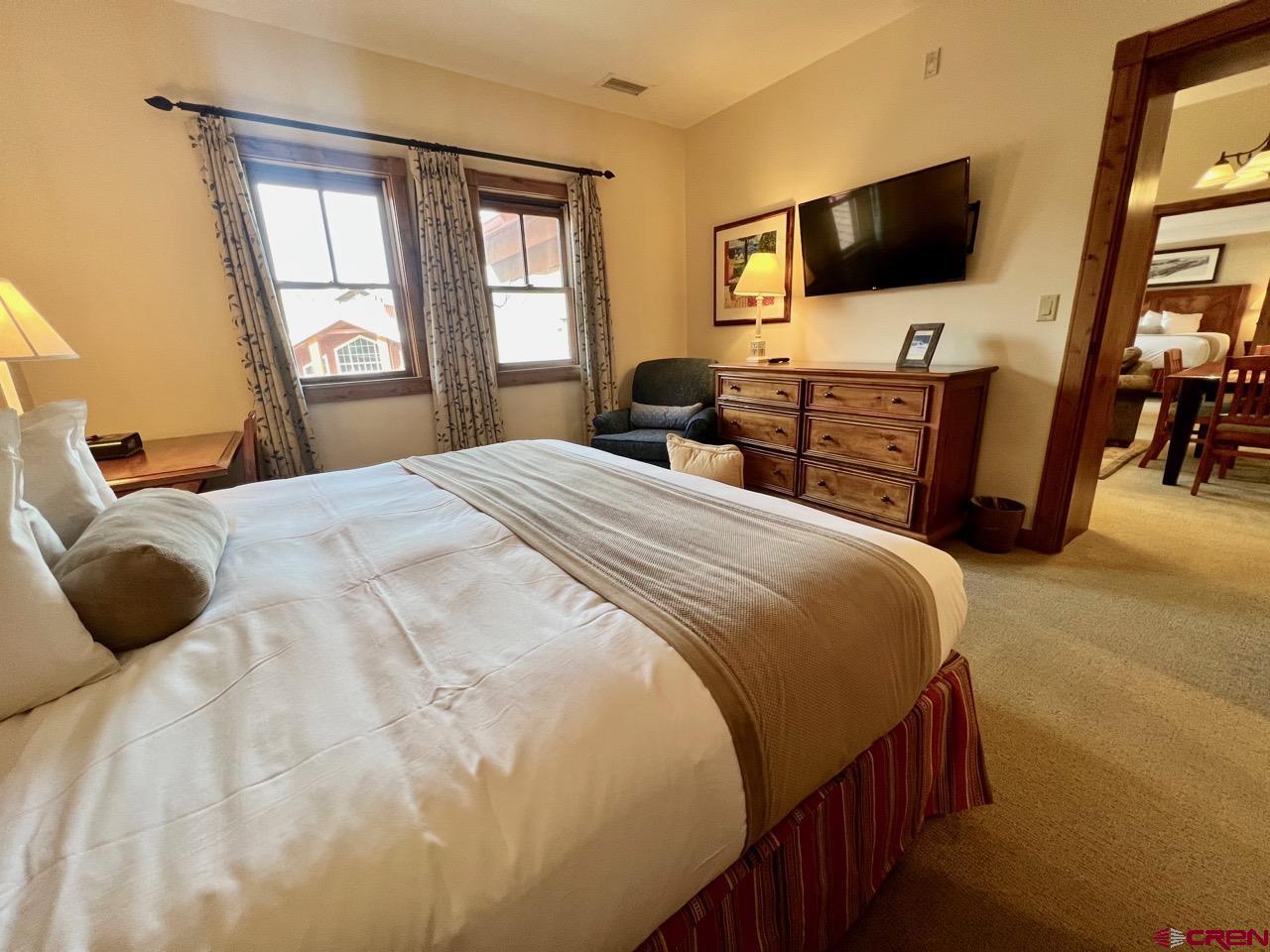 620 Gothic Road, Unit 606 Crested Butte, CO 81225 - Photo 9 of 28 a bedroom with a bed two flat screen tv and a window