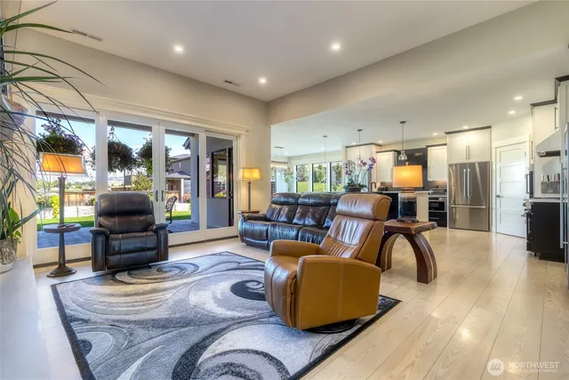 a living room with furniture kitchen view and a large window