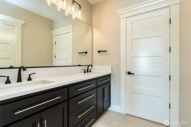 a bathroom with a double vanity sink and a mirror