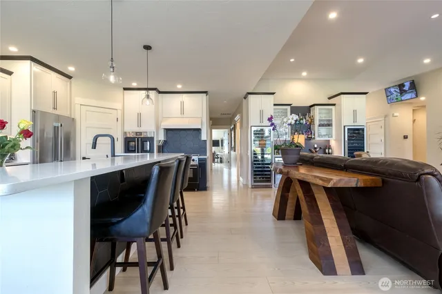 a kitchen with stainless steel appliances kitchen island granite countertop a table chairs sink and cabinets