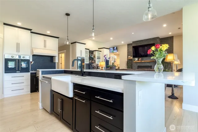 a kitchen with stainless steel appliances kitchen island granite countertop a sink and a refrigerator