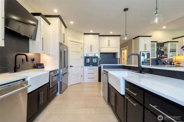 a large kitchen with stainless steel appliances lots of counter space wooden floor and a sink