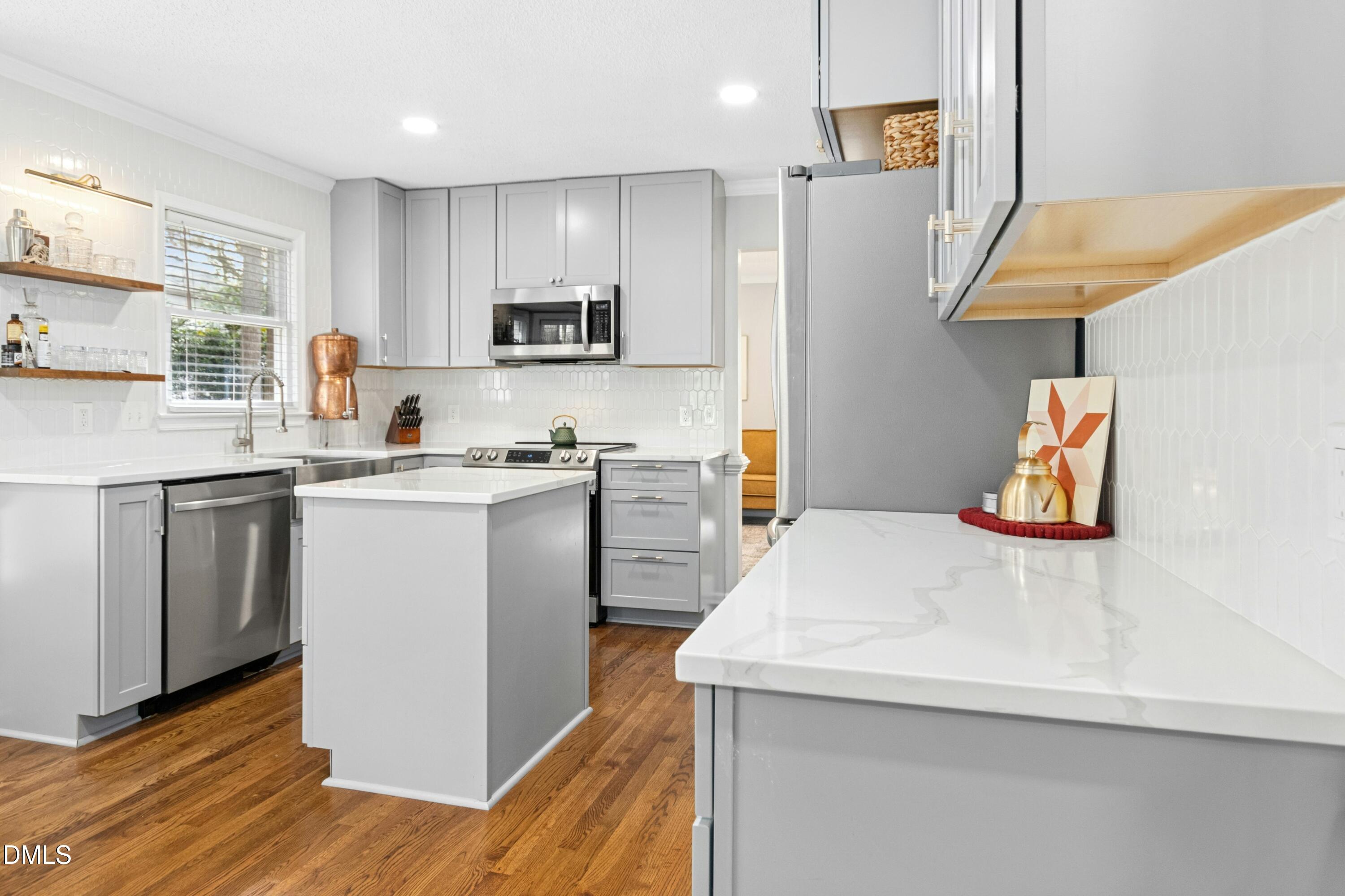 8616 Vanburgh Court Raleigh, NC 27615 - Photo 11 of 38 a kitchen with a sink a stove a refrigerator and white cabinets