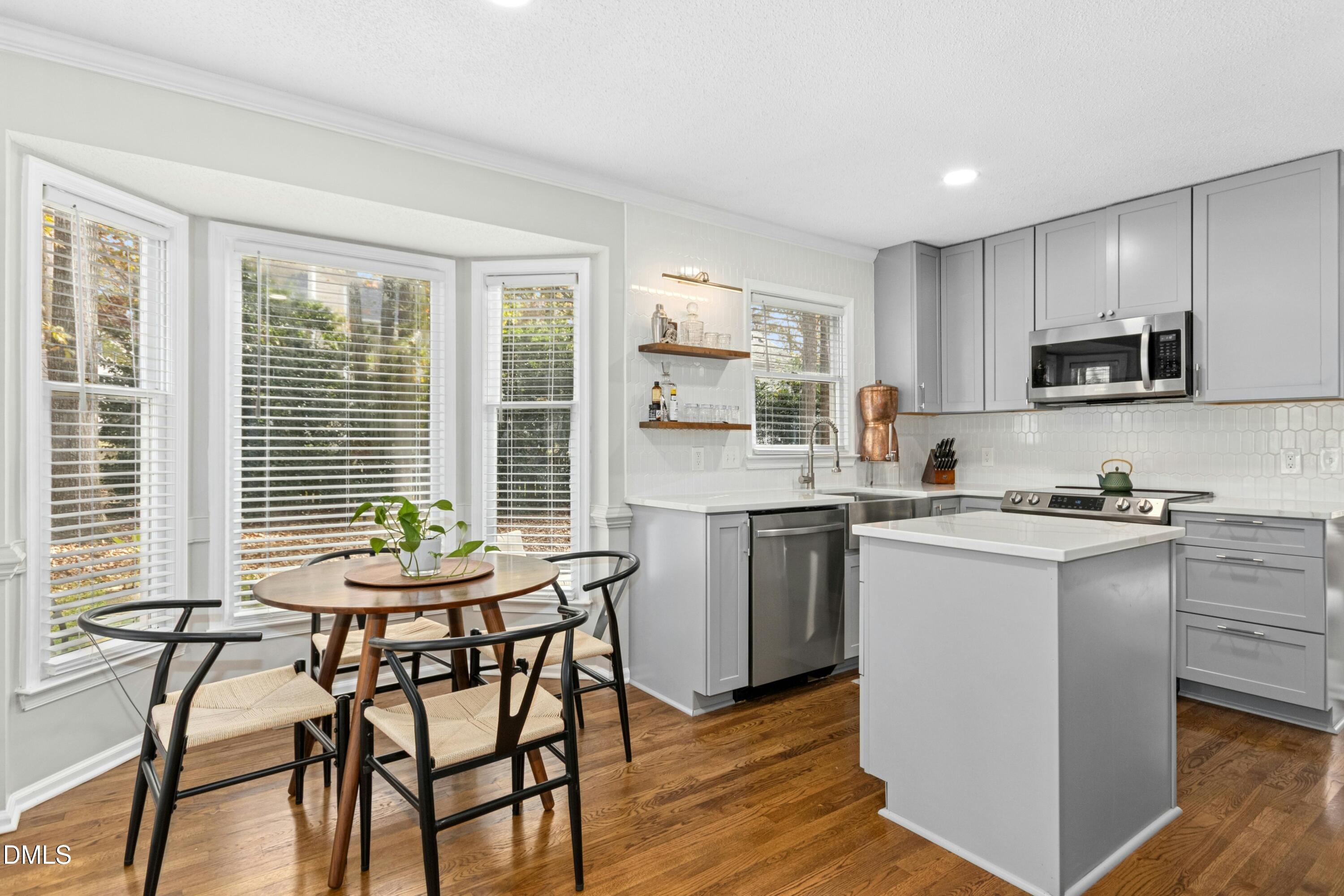 8616 Vanburgh Court Raleigh, NC 27615 - Photo 14 of 38 a kitchen with a table chairs microwave and cabinets