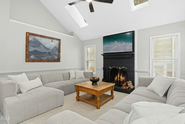 a living room with furniture a flat screen tv and a fireplace