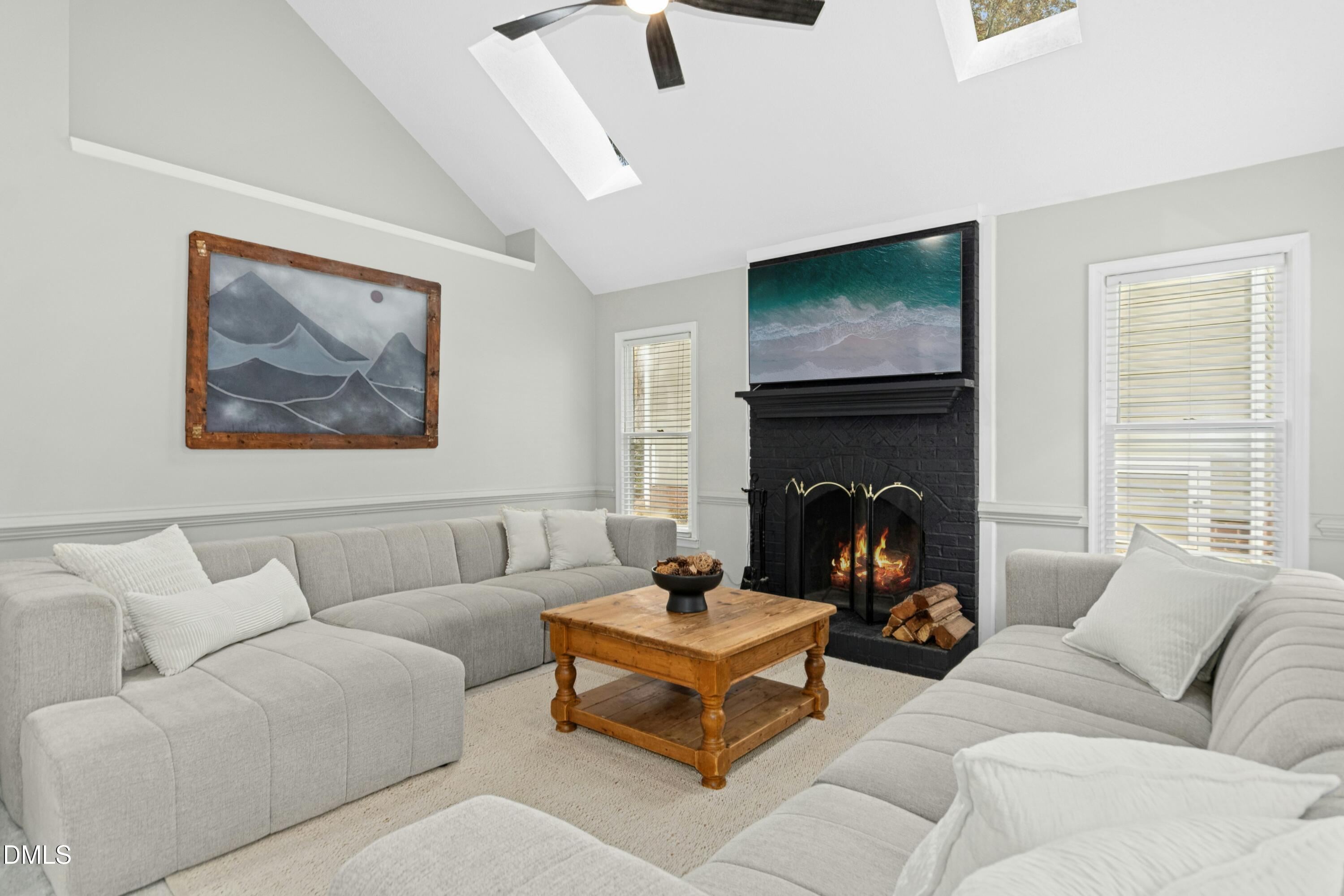 8616 Vanburgh Court Raleigh, NC 27615 - Photo 16 of 38 a living room with furniture a flat screen tv and a fireplace